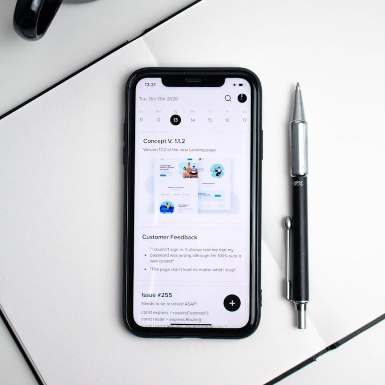 Smartphone mit Stift auf Tisch Smartphone auf einem Tisch neben einem Kugelschreiber, zeigt eine App-Oberfläche.